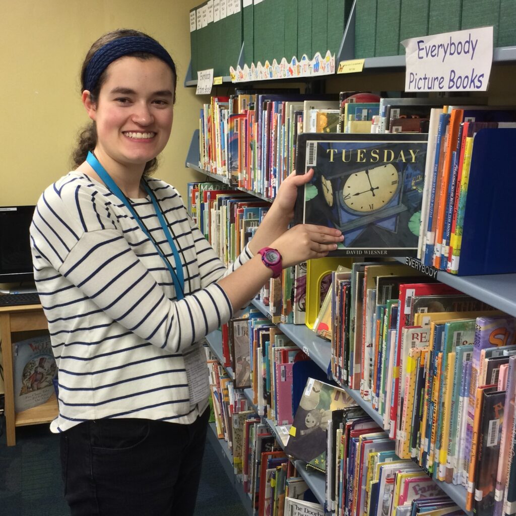 Young woman shelving books at a library